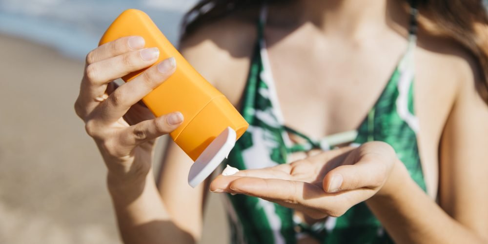 femme à la plage au soleil avec un crème solaire